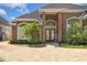 Imposing brick home featuring a brick driveway, arched windows, and professional landscaping at 220 Waterfall Circle, Little River, SC 29566