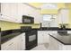 Well-equipped kitchen featuring white cabinets, granite countertops, tile floors, and ample natural light at 220 Waterfall Circle, Little River, SC 29566