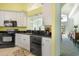 Well-lit kitchen features white cabinets, black appliances, granite countertops, and an open layout at 220 Waterfall Circle, Little River, SC 29566