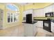 Bright kitchen features white cabinetry, black appliances, an island, and natural light at 220 Waterfall Circle, Little River, SC 29566