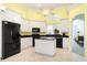 Modern kitchen featuring white cabinets, black appliances, an island, and tile floors at 220 Waterfall Circle, Little River, SC 29566
