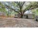 Backyard featuring a covered deck area and mature shade trees, along with a gravel surface at 2206 Beck St., Georgetown, SC 29440