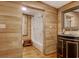 Rustic bathroom featuring wood paneling, black vanity, bathtub, and window with shutters at 2206 Beck St., Georgetown, SC 29440