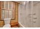 Bathroom featuring a tub with shower, wood paneling, and window with shutters at 2206 Beck St., Georgetown, SC 29440