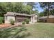 Inviting single-story home with a screened porch, set on a grassy lot with mature trees and a wooden fence at 2206 Beck St., Georgetown, SC 29440