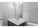 A functional bathroom featuring a black vanity, a modern mirror, and a neutral color scheme at 2258 Essex Dr. # G, Surfside Beach, SC 29575