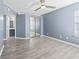 A cozy bedroom featuring wood flooring, light blue walls, and ample closet space and natural light at 2258 Essex Dr. # G, Surfside Beach, SC 29575