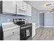Modern kitchen features white cabinets, microwave, and stainless steel oven against the blue accent wall at 2258 Essex Dr. # G, Surfside Beach, SC 29575