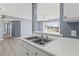 Well-lit kitchen features a double sink, white countertop and blue accent wall with vinyl floors at 2258 Essex Dr. # G, Surfside Beach, SC 29575