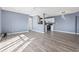 An open-concept living space featuring wood flooring, light blue walls, and a well-lit kitchen at 2258 Essex Dr. # G, Surfside Beach, SC 29575