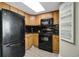 Kitchen area with black appliances, wooden cabinetry, and black countertops at 2710 N Ocean Blvd. # 804, Myrtle Beach, SC 29577