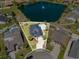 Aerial view of a beautifully landscaped home with an in-ground pool and a lake in the background at 2940 Tigers Eye Rd., Little River, SC 29566