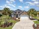 Charming brick home with a two-car garage, manicured landscaping, and palm trees at 2940 Tigers Eye Rd., Little River, SC 29566
