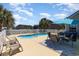 A backyard in-ground pool with seating area, a sun umbrella, and a white picket fence at 2940 Tigers Eye Rd., Little River, SC 29566