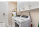 Bright laundry room equipped with washer, dryer, storage cabinets, and a water heater at 311 2Nd Ave. N # 210, North Myrtle Beach, SC 29582