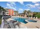Inviting pool area with lounge chairs, palm trees, and hot tub for relaxation at 311 2Nd Ave. N # 210, North Myrtle Beach, SC 29582