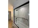 Modern bathroom with a tub and shower with a black framed sliding glass door and light vertical stack tiling at 326 15Th Ave. S, Surfside Beach, SC 29575