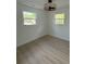 Bright bedroom with two windows, light wood floors, white walls, and a modern ceiling fan and light fixture at 326 15Th Ave. S, Surfside Beach, SC 29575