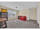 Bright room featuring neutral walls, plush carpet, a red sofa, and a bookshelf by a bright window at 381 Winslow Ave., Myrtle Beach, SC 29588