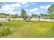 Large backyard with a white fence, a trampoline, swing set, and mature trees, perfect for outdoor activities at 4008 Scarlet Oak Ct., Myrtle Beach, SC 29579
