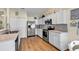 Well-appointed kitchen features white cabinets, stainless steel appliances, and modern backsplash, with wood-look flooring at 4008 Scarlet Oak Ct., Myrtle Beach, SC 29579