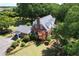 Aerial view of the beautiful brick home with a spacious yard featuring mature trees and lush landscaping at 402 E Broad St., Hemingway, SC 29554