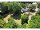 Aerial view showcases a home nestled in a lush landscape with sprawling lawns and mature trees at 402 E Broad St., Hemingway, SC 29554