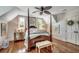 Traditional primary bedroom with four-poster bed, hardwood floors, and bright natural light at 402 E Broad St., Hemingway, SC 29554