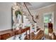 Inviting foyer with hardwood floors, elegant staircase, console table with mirror, and views to other rooms at 402 E Broad St., Hemingway, SC 29554