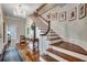 Elegant foyer features hardwood floors, a staircase with white railings, and a chandelier adding a touch of sophistication at 402 E Broad St., Hemingway, SC 29554