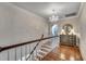 Bright hallway features hardwood floors, chandelier, and decorative chest with round mirror above at 402 E Broad St., Hemingway, SC 29554