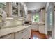 Bright kitchen features custom cabinets, granite countertops, tile backsplash, and hardwood flooring at 402 E Broad St., Hemingway, SC 29554