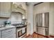 Modern kitchen with a stainless steel oven, refrigerator, granite countertop, and custom white cabinets at 402 E Broad St., Hemingway, SC 29554