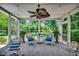 Relaxing screened porch with ceiling fan, white wicker furniture, and views of a lush green yard at 402 E Broad St., Hemingway, SC 29554