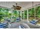 Relaxing screened porch with ceiling fan, wicker furniture, swing, and views of a lush green yard at 402 E Broad St., Hemingway, SC 29554