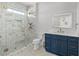 Bathroom with glass enclosed shower, hexagon tile flooring, marble counters, and blue cabinets at 4206 S Ocean Blvd., North Myrtle Beach, SC 29582