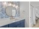 Stylish bathroom with a blue vanity, round mirror, and updated fixtures at 4206 S Ocean Blvd., North Myrtle Beach, SC 29582