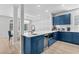 Kitchen with bar seating, white counters, blue cabinets, wine fridge and stainless appliances at 4206 S Ocean Blvd., North Myrtle Beach, SC 29582