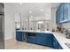 Kitchen with bar seating, white counters, wine fridge, stainless appliances and blue cabinets at 4206 S Ocean Blvd., North Myrtle Beach, SC 29582
