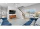 Bright living room with a ceiling fan, comfortable blue couches and staircase to the second floor at 4206 S Ocean Blvd., North Myrtle Beach, SC 29582