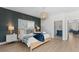 Bedroom with accent wall, chandelier, wood-look flooring, and en-suite bath at 4206 S Ocean Blvd., North Myrtle Beach, SC 29582