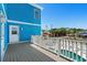 View of blue home exterior and pool from wood deck with white railings at 4206 S Ocean Blvd., North Myrtle Beach, SC 29582