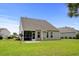 Beautiful backyard view featuring a screened porch, manicured lawn, and mature landscaping at 4246 Livorn Loop, Myrtle Beach, SC 29579
