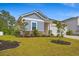 Beautifully landscaped front yard of a single-Gathering home with vibrant green grass and young trees at 4609 Day Lily Run St., Myrtle Beach, SC 29579