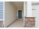 Covered entryway with stone accents leading to a stylish blue front door and spacious porch at 4609 Day Lily Run St., Myrtle Beach, SC 29579