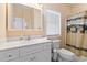 Bright bathroom featuring a white vanity with storage, toilet, and shower with themed curtain at 48 Sw Wilmington St., Ocean Isle Beach, NC 28469