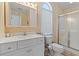 Bright bathroom featuring a white vanity, arch window, and glass enclosed shower at 48 Sw Wilmington St., Ocean Isle Beach, NC 28469