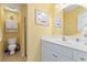 Clean bathroom featuring a sink with a mirror, wall art, toilet, and a shower at 48 Sw Wilmington St., Ocean Isle Beach, NC 28469