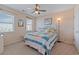 Inviting bedroom features a cozy bed with a colorful quilt, ceiling fan, and natural light at 48 Sw Wilmington St., Ocean Isle Beach, NC 28469