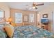Relaxing bedroom with ceiling fan, TV, nautical themed bedding, and natural light at 48 Sw Wilmington St., Ocean Isle Beach, NC 28469